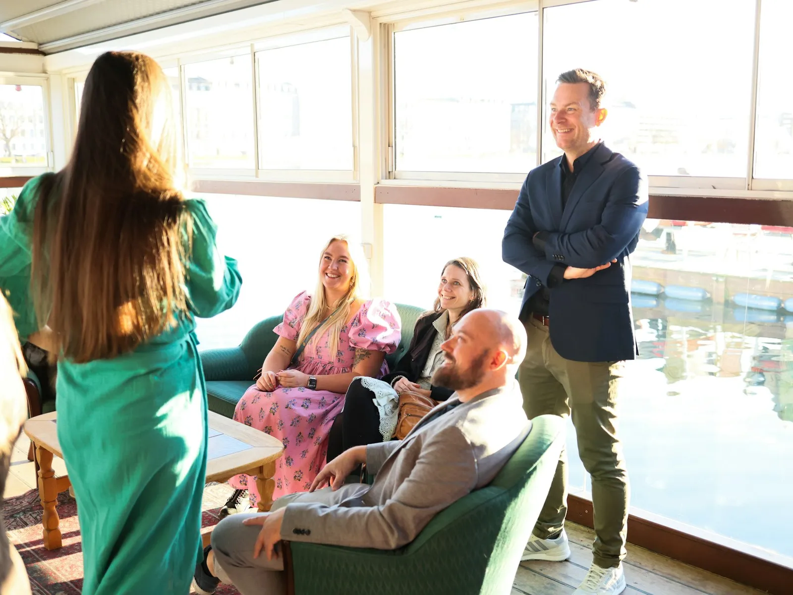 A smart-casual group sharing conversation in a bright lounge